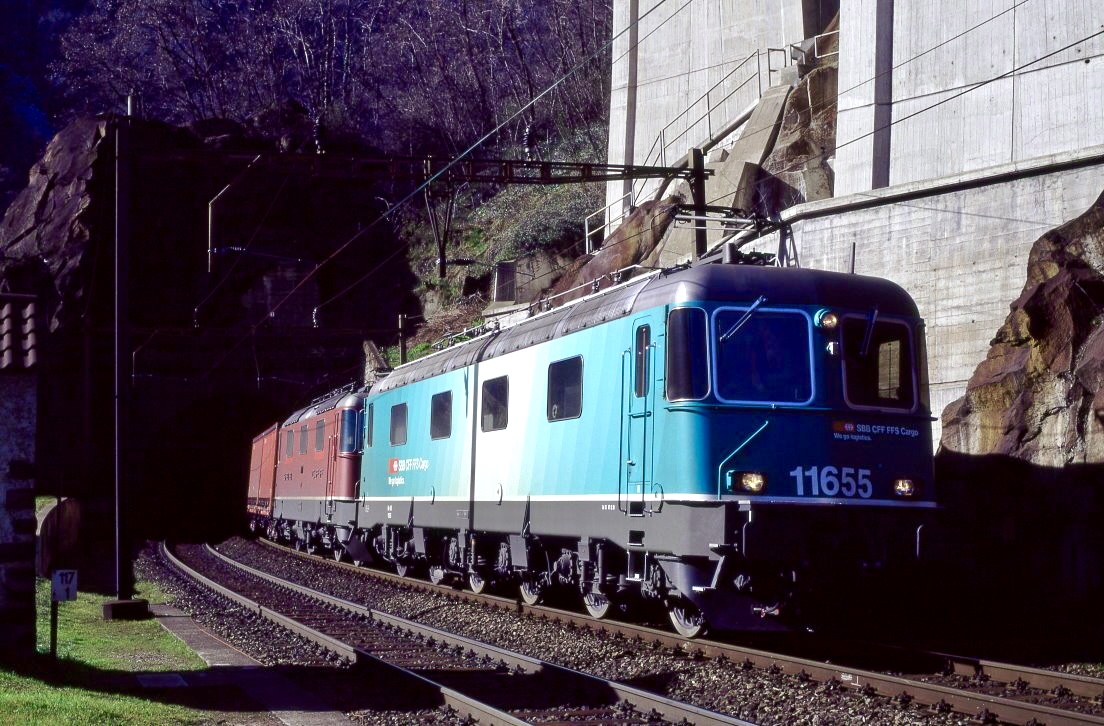 So htten die Loks von SBB Cargo aussehen knne, wenn sich diese Versuchslackierung durchgesetzt htte. Re 6/6 11655 und Re 4/4 11171 mhen sich bei Biaschina die Gotthard-Sdrampe hinauf. Aufnahme direkt unter der Autobahn in der mittleren der dortigen drei Ebenen der Strecke, 08.03.2000.