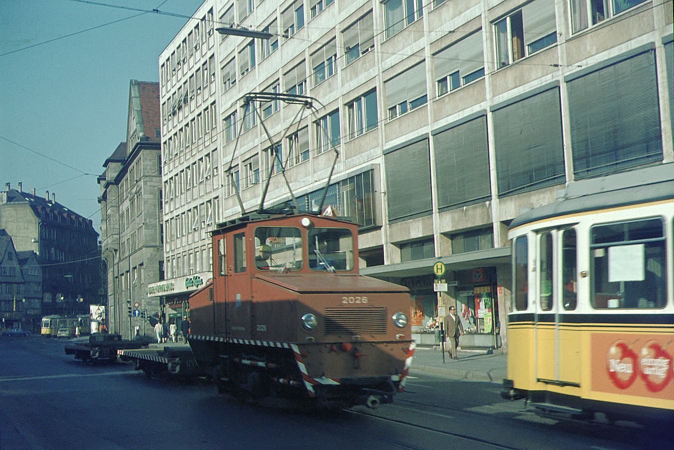 SSB Stuttgart__Arbeitsfahrzeuge der SSB in den 70er und 80er Jahren. A-Lok 2026 [ME/BBC 1946; +1977] mit 2 Flachwagen in der Eberhardstr. vor der Seitenfront des Rathauses.__1970 