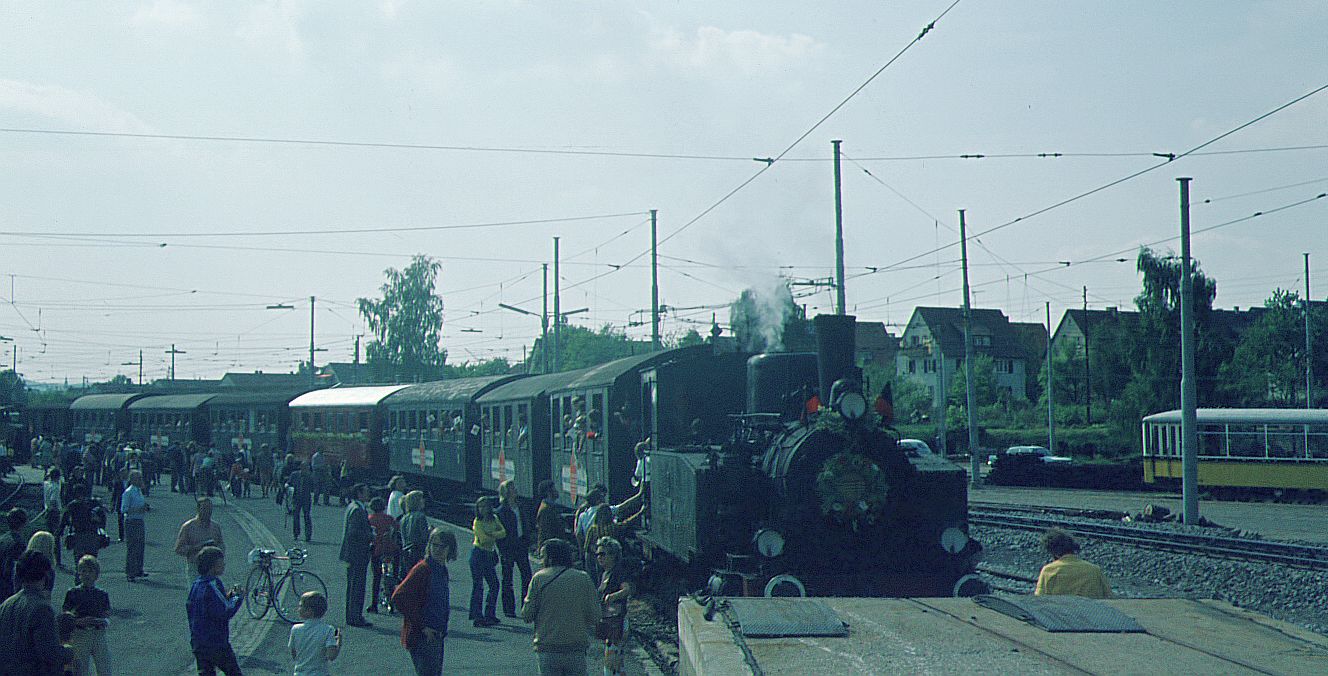 SSB Stuttgart_Filderbahn__Lok 11 [ME 1911 für HzL (Hohenzollerische Landesbahn), ab 1970 GES-Eigentum] mit ihrem Zug von Neuhausen/F. an der Laderampe im Bf Möhringen. Rechts einer der dort hinterstellten SSB 1300er-Bw.__26-05-1973