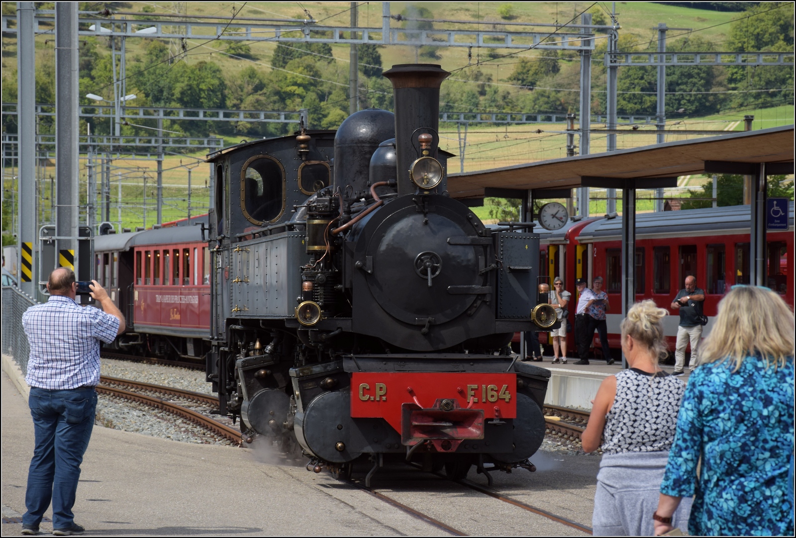 Train a vapeur de Franches-Montagnes von La Traction.

Hier verlässt CP E164 den Strassenbereich, der bis vor nicht allzulanger Zeit noch der  Bahnsteig  für die Züge auf die Freiberge war. September 2022.