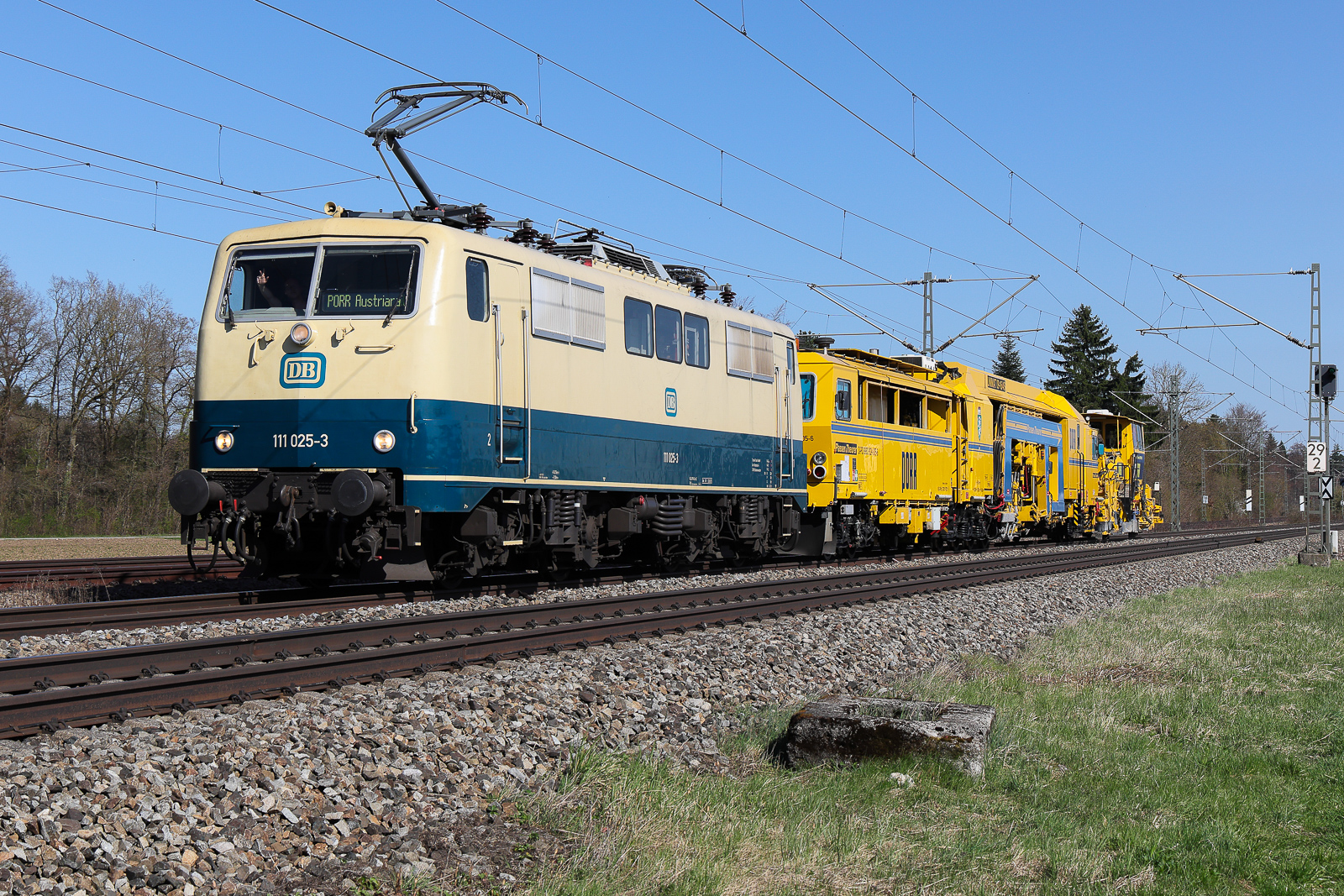 Train4Train GmbH, Bodenwerder mit ihrer  111 025-3  (NVR:  91 80 6111 025-3 D-TFT ) mit einem Bauzug und einem gut gelaunten Lokführer am 7. April 2026 bei Eglharting. Ist am Vortag Lz nach Rosenheim gefahren und hat dann heute Stunden lang auf sich warten lassen. Aber da Ergebniss kann sich ja sehen lassen.
