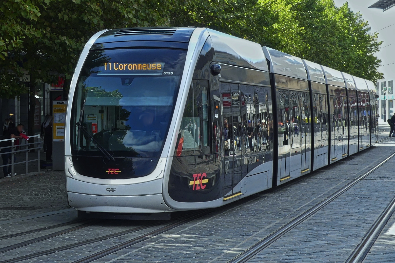 Tram 5120 des Tec, in Lüttich an der Haltestelle Place Saint Lambert, hier biegt sie in die Rue Léopold ab, die nächsten 2 Haltestellen La Batte und Curtius werden nur aus dieser Richtung angefahren, weil ab hier die Linie eingleisig verläuft, zwischen Curtius und Marengo biegt die Bahn aus der anderen Richtung in eine Nebenstraße ab bis zur Place Saint Lambert, von hier geht es wieder zweigleisig weiter. 09.2025
