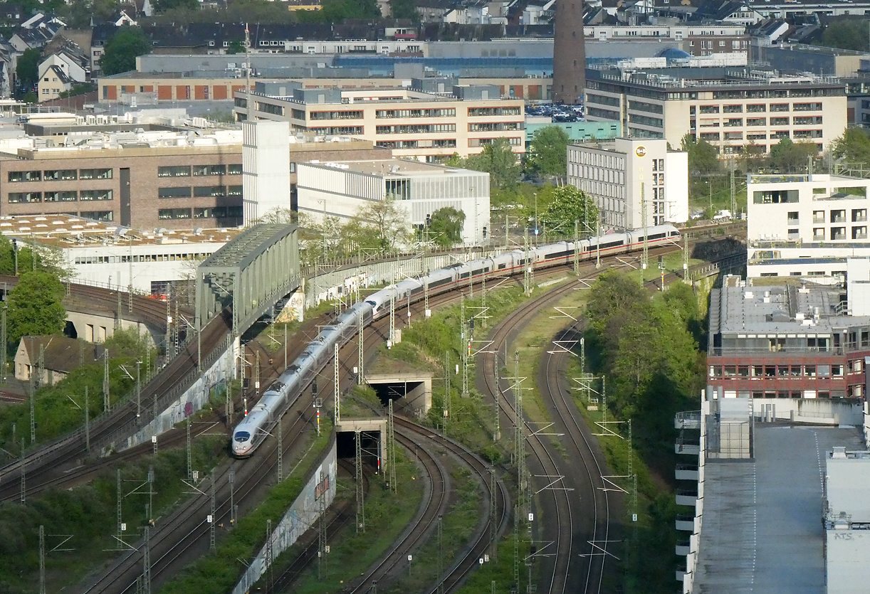 Ueberwerfungen und Tunnels sorgen für interessante Gleisführungen. Ein ICE fährt beim Bahnhof Köln Messe/Deutz von der Sonne in den Schatten. Das Foto wurde von der Aussichtsplattform 'Triangle' aufgenommen. Köln, 18.4.2024