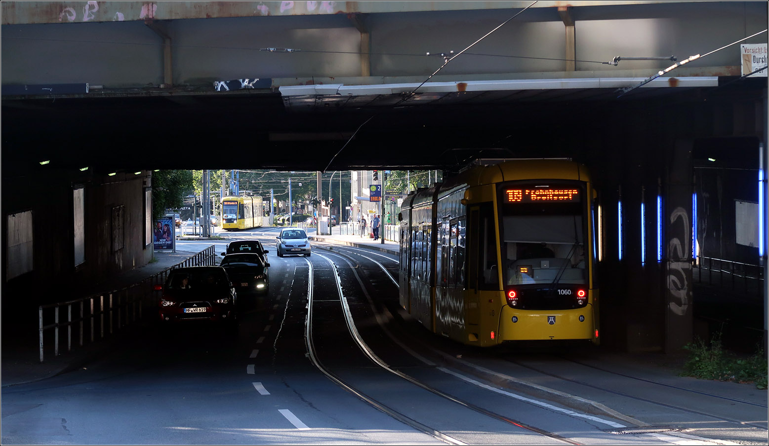 Unter der Bahnbrücke der Steeler Straße - 

Eine Alstom Flexity M8D-NF4 unterfährt die Bahnstrecke westlich des Essener Hauptbahnhofes, während jenseits der Brücke in Tram der Vorgängerserie M8D-NF2 noch in der Haltestelle Hollerstraße steht.

23.08.2023 (M)