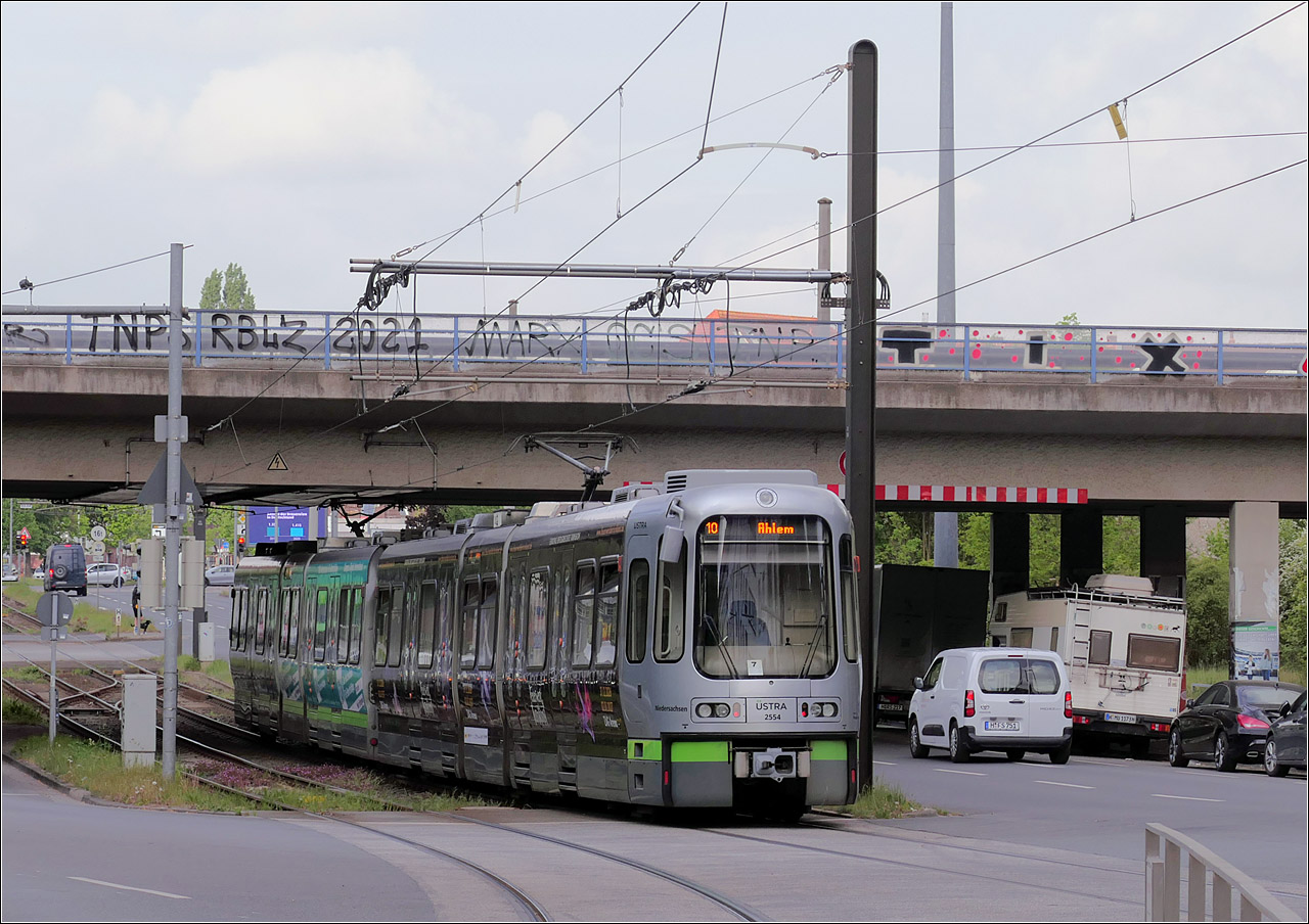 Unter dem Westschnellweg hindurch - 

... f�hrt hier eine Stadtbahnzug (2596 + 2554) nach dem Halt am Freizeitheim Linden der Linie 10 in Richtung Ahlem. Nach der Ortsdurchfahrt von Linden-Nord gibt es hier wieder einen eigenen Bahnk�rper. Der folgende Stadtteil Limmer wird dann wieder auf den Stra�enfahrbahnen durchfahren.

04.05.2026 (M)

 
