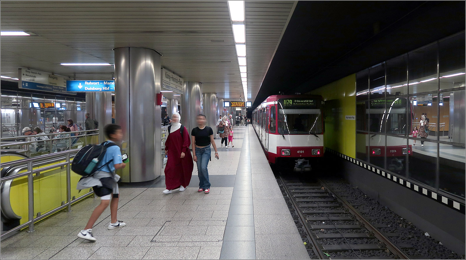 Unter Duisburger Fußgängerzone - 

... liegt die doppelstöckige, viergleisige Station König-Heinrich-Platz. In der oberen Ebene (Bild) verkehren die Linien U79 und 903, während ein Stockwerk tiefer die Linie 901 verkehrt. Die beiden Strecken fahren hier also im Linienbetrieb, während am benachbarten Hauptbahnhof Richtungsbetrieb herrscht, um am selben Bahnsteig direkt umsteigen zu können. Die großzügigen viergleisige Tunnelanlagen sind nur, wie an vielen anderen Stellen der Stadtbahn Rhein-Ruhr nur mit der ursprünglichen Planungen einer echten U-Bahn für das gesamte Ruhrgebiet einschließlich Düsseldorf zu verstehen. 

23.08.2023 (M)