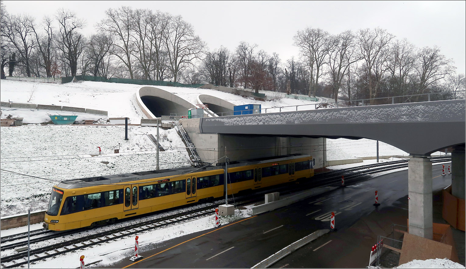 Unterhalb der zukünftigen Tunneleinfahrten -

... unterfährt ein Stadtbahnzug der Stuttgarter Linie U13 die neue Neckarbrücke der Bahn.

Ich nutzte heute die feine Schneedecke um einen kleine Ausflug hierher zu machen, da so der noch nicht begrünte Hang und sein Umfeld eine Einheit bilden und damit den Baustellen-Charakter an dieser Stelle mildert.

Durch seine gelbe Farbe zieht aber der Stadtbahnwagen die Blicke auf sich.

Stuttgart-Bad Cannstatt, 22.01.2023 (M)