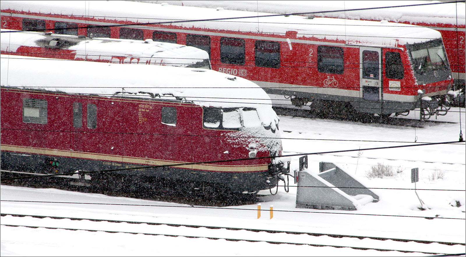 Unterschiedliches Rot im Weißen - 

Abgestellte Dieseltriebwagen am Ulmer Hauptbahnhof. Unten ein historische Triebwagen VT 12.5 bzw. Baureihe 612, dessen weinrote Farbe vom Verkehrsrot der modernen Triebwagen dahinter abweicht.
Das interessantes an dem Motiv sind die schneebedeckten Frontscheiben, wobei die Scheibenwischer der inneren Scheiben den Schnee zusätzlich halten, sowie das fast nicht mehr sichtbar V darunter. 

17.01.2016 (M)



