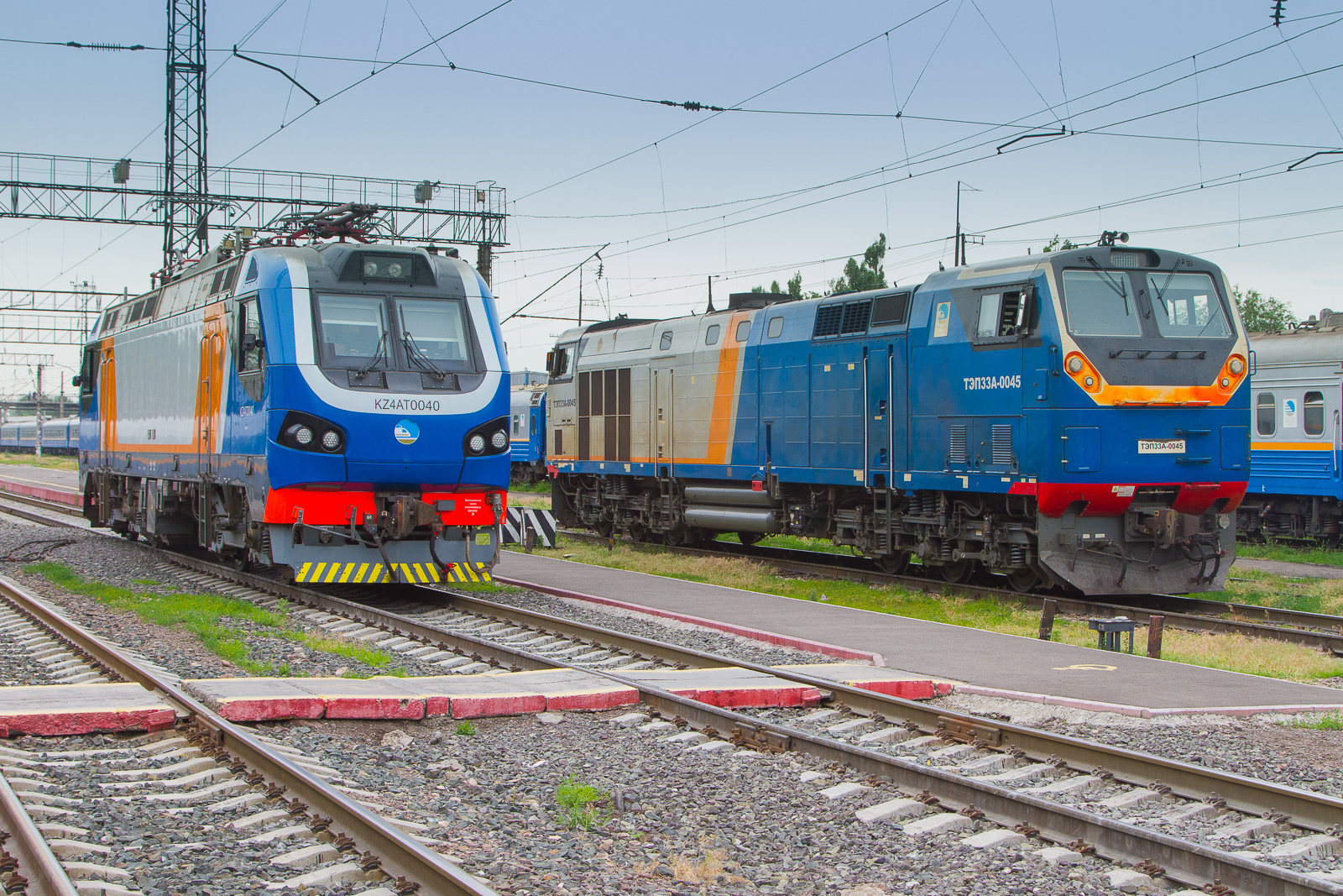 Vergleich neu und alt der nationalen Eisenbahngesellschaft Qazaqstan Temir Joly (QTJ). Bahnhof Almaty 2 am 6 Juni 2026 mit  KZ4AT0040 und T3P 33A -0045.