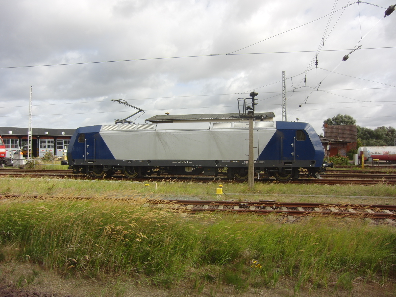 Vor dem Lokschuppen in Wismar steht 145 015-4 D-DB in den Farben von RBH.