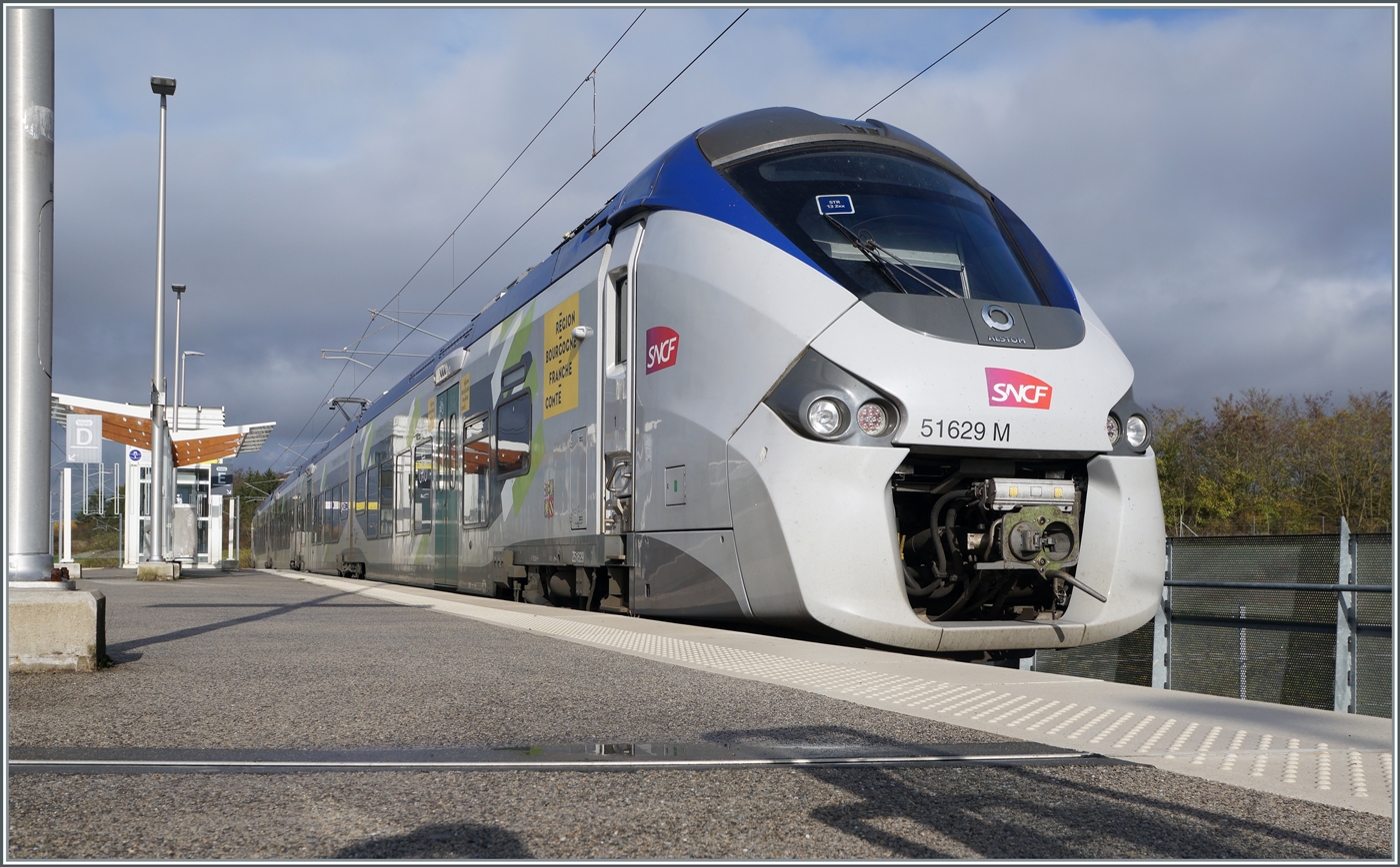 Vor einem dunklen Himmel im hellen Sonnenlicht zeigt sich für eine knappe Stunde der SNCF Coradia Polyvalent Régiolis 51629M im Bahnhof von Meroux. 
Der SNCF Coradia Polyvalent Régiolis 51629M ist als MOBOGO TER 895055 von Belfort um 10:10 angekommen und wird als MOBIGO TER 895054 um 11:03 nach Belfort zurückfahren. 

3. November 2025 