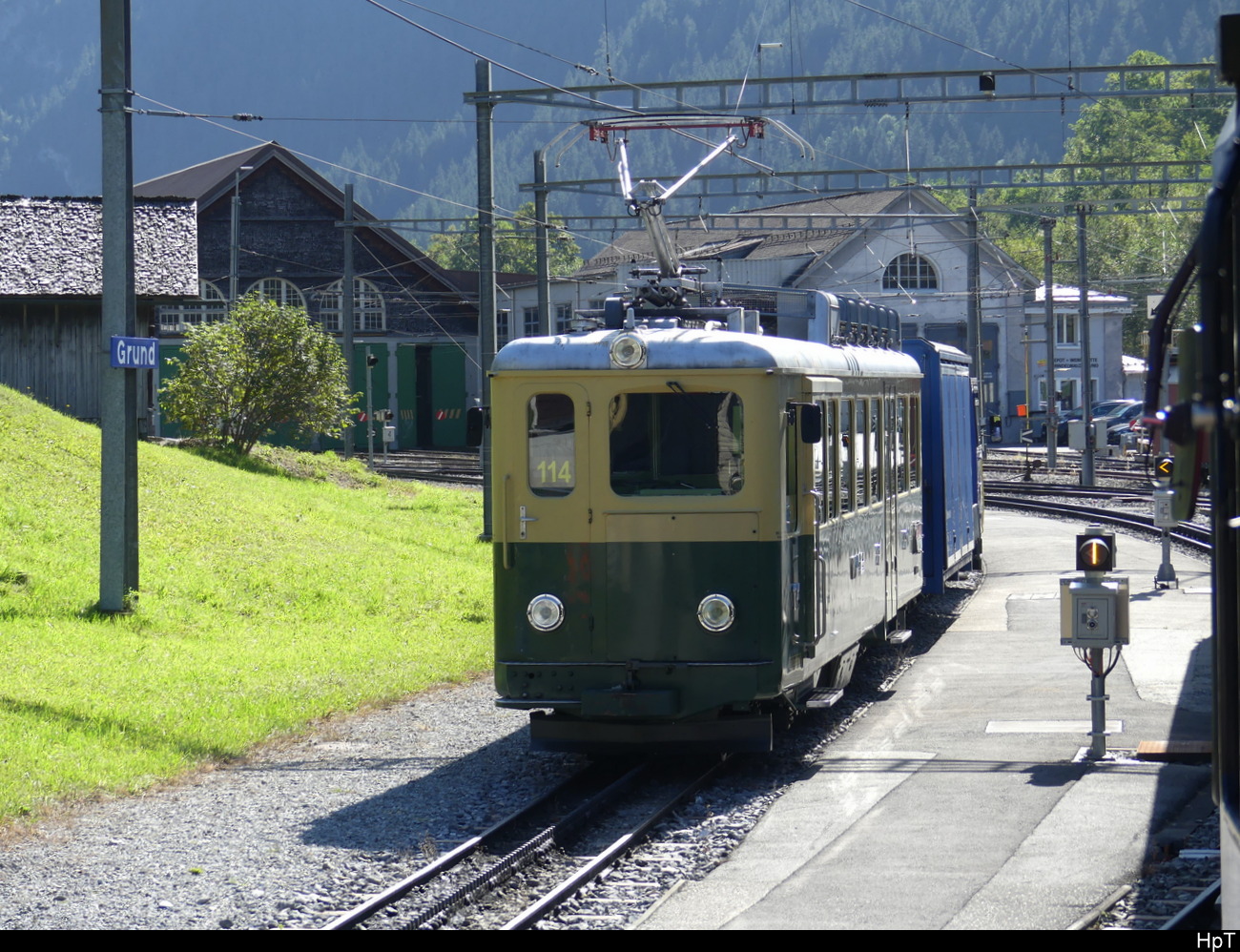 WAB - BDhe 4/4 114 am Warten im Bhf. Grindelwald Grund am 28.09.2023 .. Bild wurde vom ausfahrendem Zug hinaus gemacht.