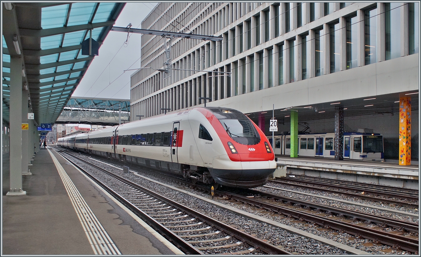 Während ein SBB ICN RABDe 500 als IC 5 1523 von Lausanne nach Zürich ohne Halt durch den Bahnhof von Renens VD fährt, warten im Hintergrund zwei TL TSOL Be 4/6 (Be 558) als m1 auf die Abfahrt nach Lausanne Flon. 

14. Dezember 2023