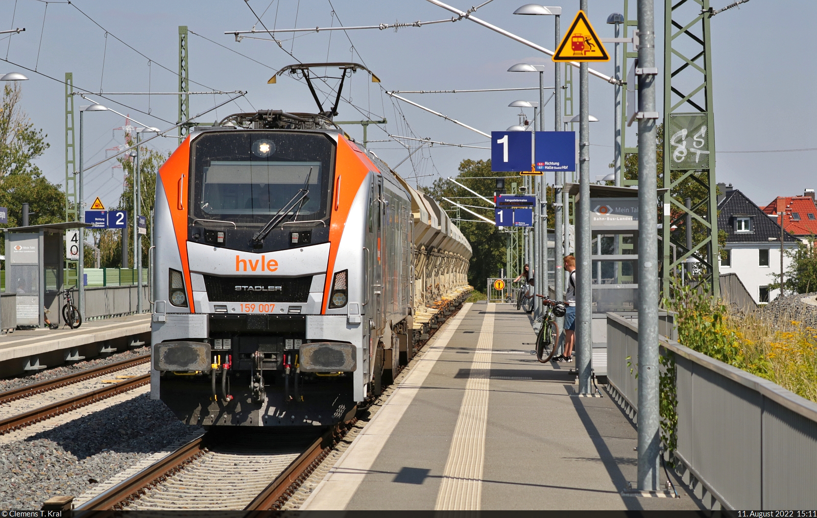 Während die Fahrgäste im Hp Halle Rosengarten an Gleis 1 die S-Bahn erwarten, kommt aus der Gegenrichtung erst einmal noch 159 007-4 (Stadler Eurodual) mit Kies im Anhang durchgefahren. Trotz ihrer beachtlichen Leistung hatte die Lok sichtlich Mühe, zu beschleunigen.

🧰 Havelländische Eisenbahn AG (HVLE)
🕓 11.8.2022 | 15:11 Uhr