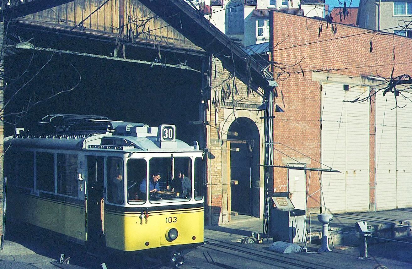 Zahnradbahn Stuttgart__Kleiner Rückblick am selben Ort : aus der offenen ursprünglichen Bahnhofshalle von 1884 lugt Tw 103 (ME, 1937) hervor, mit der Plattform schon über der damaligen Schiebebühne.
Bis zur Inbetriebnahme des zweigleisigen Zahnradbahnhofs am Marienplatz 1936 (dort, wo heute das armselige, Designer-bestimmte? Haltestellendächlein zu finden ist) war seit 1884 diese Halle an der Filderstr. der Talbhf.__17-02-1975