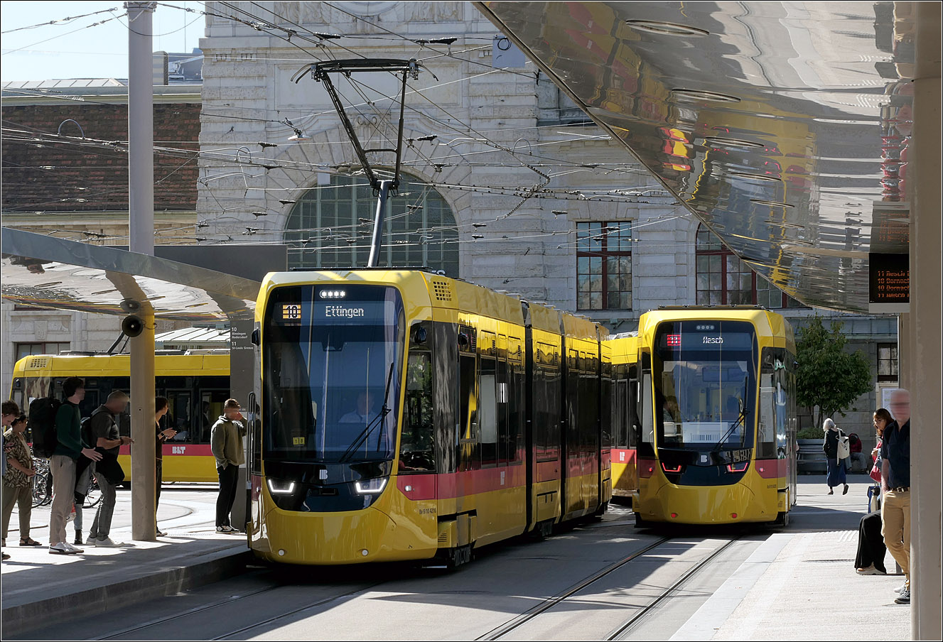 Zwei 'Erdbebenträmmli' - 

... begegnen sich an der Haltestelle Bahnhof SBB in Basel. Da die Stadler Tina Fahrzeuge zumindest anfangs recht laut waren, bekamen sie diesen Spitznamen. Inzwischen hat Stadler nachgebessert und die Bahnen haben wohl das Niveau der Tango-Trams erreicht. In Darmstadt gab es ähnliche Probleme mit den dortigen Tinas.

Vom Design her machen sie aber ein guter Figur nach meinem Empfinden.

18.09.2025 (M)

