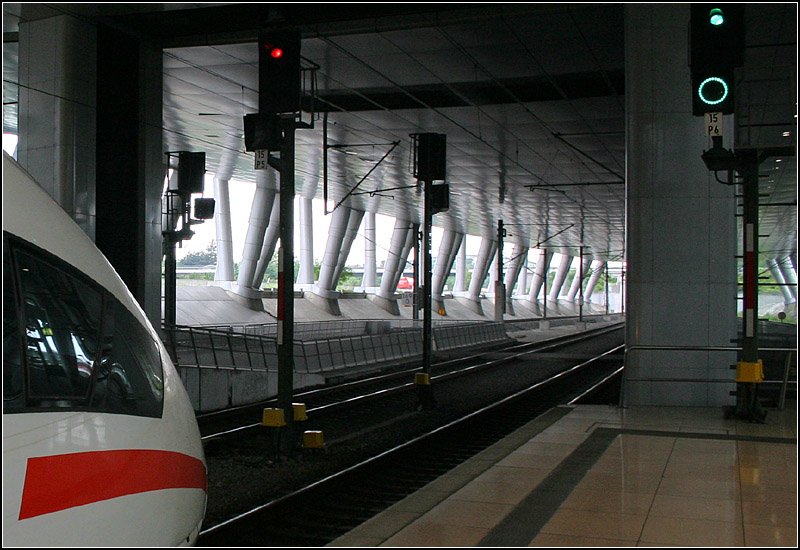 . Überbauung -

Die westliche Ausfahrt aus dem Fernbahnhof am Frankfurter Flughafen. Die Deckenplatte wird hier über den Gleisen weitergeführt. Auf dieser Platte entsteht derzeit über dem gesamten Bahnhof das sogenannte  Airrail Center , ein neun geschossiges Bauwerk, für Büros, Hotels, Gastronomie und Einzelhandel. Die Glaskuppel erhalten. 

01.06.2006 (M)