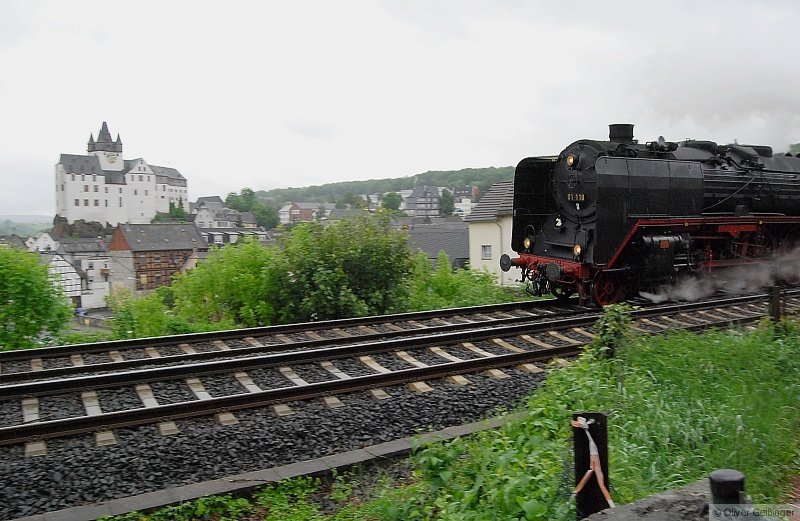 01 118 der Frankfurter historischen Eisenbahn auf Durchreise in Diez/Lahn. Das Wetter war dermaßen ungemütlich und dunkel, dass es trotz hoher ISO-Zahl nicht möglich war, die Bewegungsunschärfe auszumerzen. Nur halbwegs gelungen daher das Bild von Schloss Diez und Lok, dennoch mit historischem Charme. (11. Mai 2009)