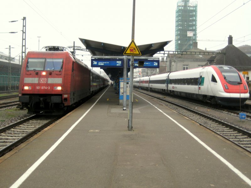 101 074 mit dem IC 2004 nach Emden, daneben ICN  Xaver Stockmar  nach Biel an einem grauen Novembertag in Konstanz.