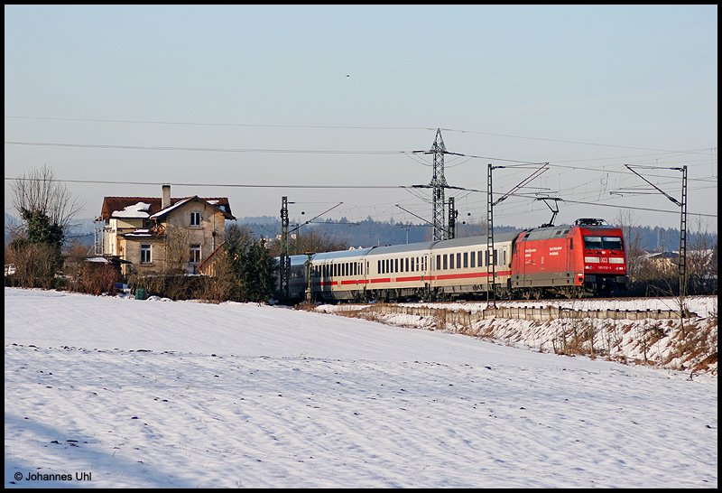 101 112-1 zog am Morgen des 25.02.2009 einen IC von Karlsruhe nach Nrnberg. Hier aufgenommen in einem mit einer Schnee-Eis-Schicht bedecktem Feld in der Nhe von Aalen-Hofen kurz bevor der Zug den Bahnhof Goldshfe passiert hatte. Das auf dem Bild zu sehende Haus war frher einmal Bahneigentum, ist heute allerdings in Privatbesitz. 
