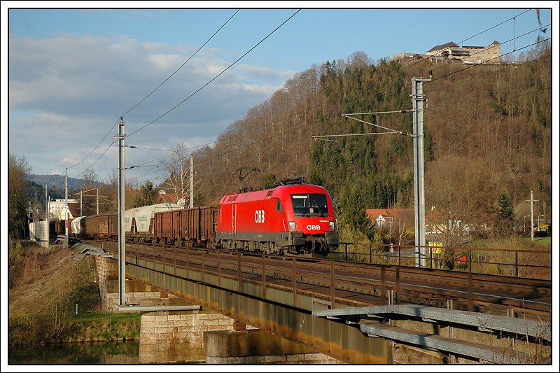 1016 005 mit ihrem Gterzug bei der Querung der Mur kurz vor Bruck an der Mur mit der Burg Oberkapfenberg im Hintergrund, aufgenommen am 5.4.2008.