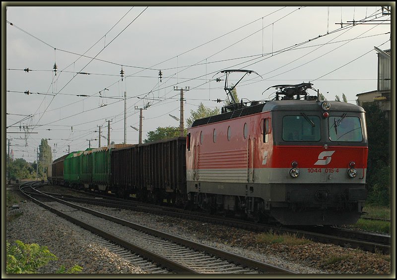 1044 015 am 17.9.2006 mit einem Gterzug kurz vor der Durchfahrt der S-Bahnstation Wien Atzgersdorf-Mauer.