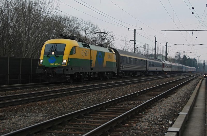 1047 503 vor dem Schnellzug 346  Dacia  von Bukarest nach Wien Westbahnhof kurz vor Bruck an der Leitha. Fotografiert am 15.03 bei Nieselregen und schlechtem Licht.