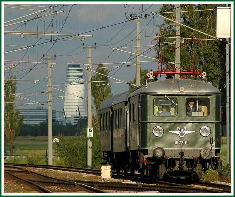 1072.01 mit ihrem Sonderzug R 16405 am 10.6.2006 von Wolfsthal kommend bei der Durchfahrt der Haltestelle Mannswrth. Im Hintergrund ist der Tower des Flughafen Wien zu sehen.