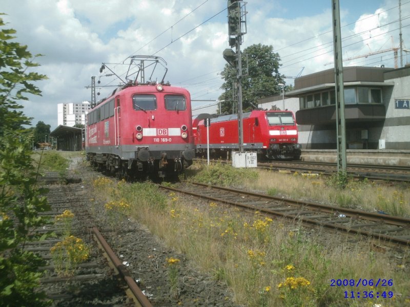 110 0169-0 am Prellbock, das 3 kpfige Personal steigt aus,
um eine grere Pwise beim Bcker im Bahnhof zu machen.
Dahinter ein RE nach Braunscfeihkeig mit einer 146.1