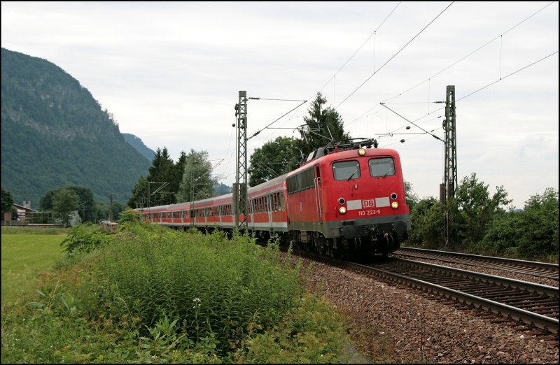 110 223 ist mit dem RE 30103 von Rosenheim nach Kufstein unterwegs und legt sich beim Kloster Raisach in die Kurve. (04.07.2008)
