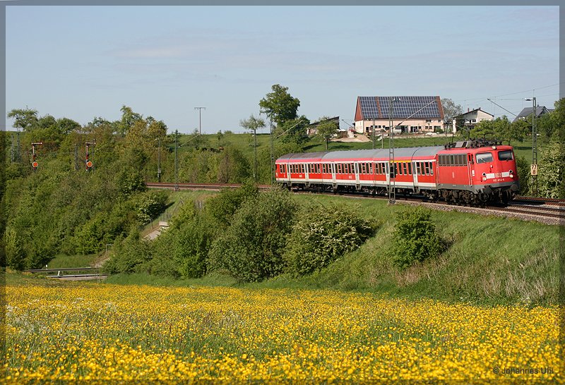 110 454-6 war am 7.05.2009 mit ihrer RB auf der Strecke Donauwrth-Aalen unterwegs. Hier hat sie mit ihrem Zug gerade den Bahnhof Goldshfe verlassen und fhrt durch die blhenden Wiesen in Aalen-Oberalfingen hindurch dem Zielbahnhof Aalen entgegen.