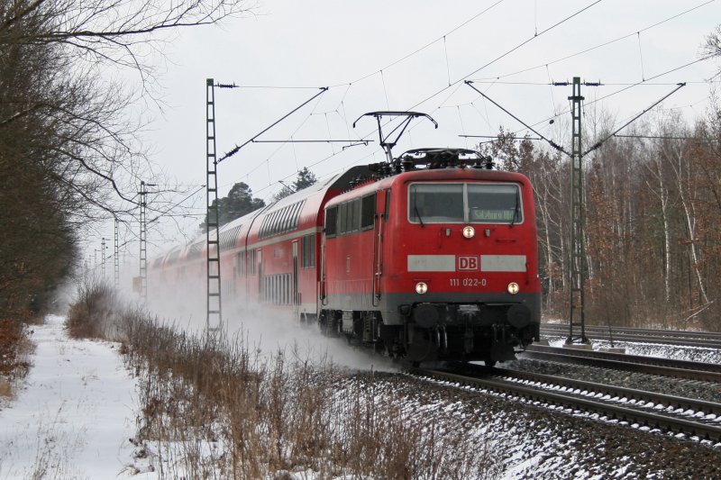 111 022 mit RB 30019 wirbelt den frisch gefallen Schnee auf. Aufgenommen am 13.02.2009 in Haar (bei Mnchen).