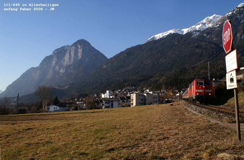 111-045 hat die Martinswand (im Hintergrunde zu sehen) hinter sich gelassen, um ihren aus Mnchen kommenden Zug nach Innsbruck hinunterzugeleiten. Das erste der Vorsignale des Bahnhofs Htting hat sie schon passiert. Anfang Feber 2008 kHds