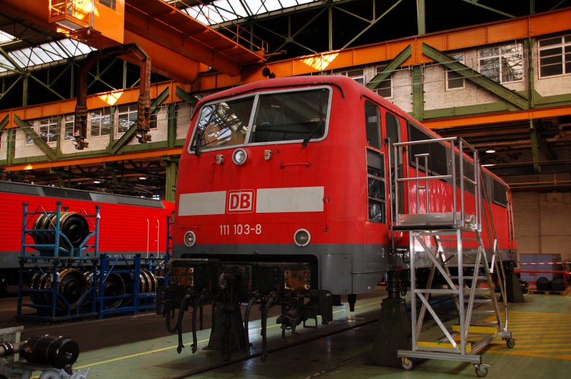 111 103 steht aufgebockt im Werk Dessau. Neben den Stromabnehmern fehlen auch die Puffer.