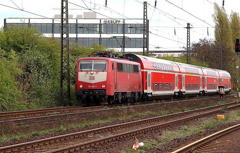 111 149 raucht mit einem RE am ehemaligen Verwaltungsgebude von Krupp in Rheinhausen vorbei. 18.04.2004