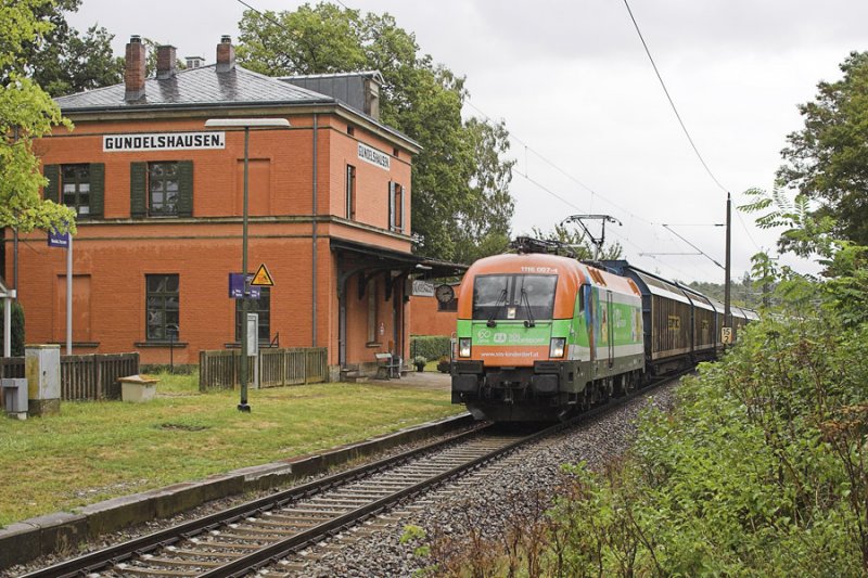 1116 007 mit dem sehr im Minus liegenden Audi-Zug nach Ungarn bei der Durchfahrt des Haltepunktes Gundelshausen.