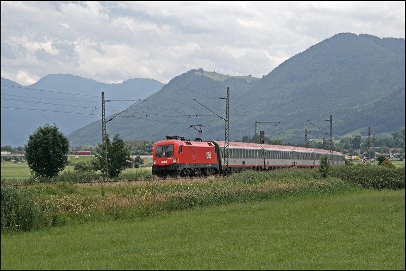 1116 045 legt sich vor den Chiemgauer Bergen mit dem EC 114  WRTHERSEE , auf der Reise von Klagenfurt Hbf nach Dortmund Hbf, in die Kurve. In ber Sechs Stunden wird der Zug das Ziel erreichen. (09.07.2008)

