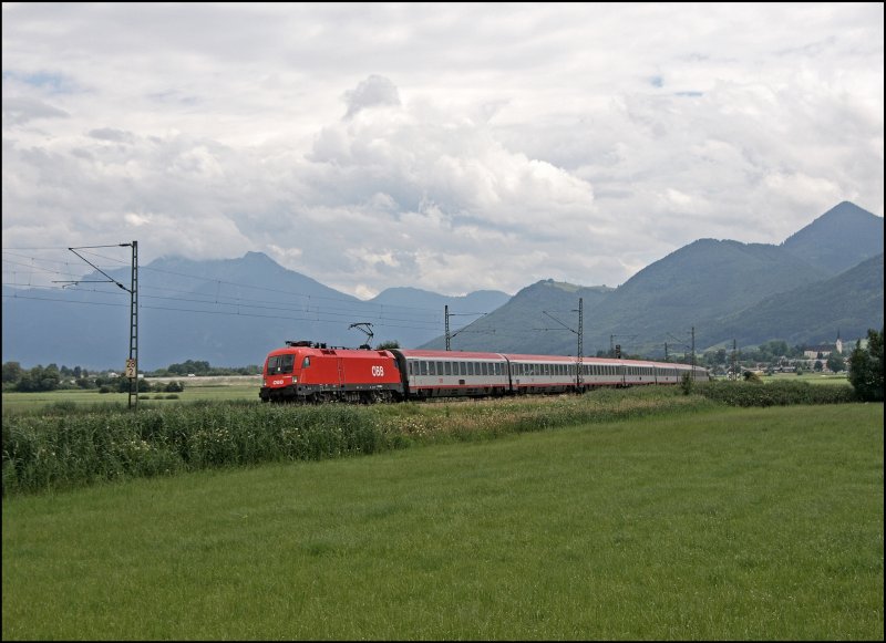 1116 045 legt sich vor den Chiemgauer Bergen mit dem EC 114  WRTHERSEE , auf der Reise von Klagenfurt Hbf nach Dortmund Hbf, in die Kurve. (09.07.2008)