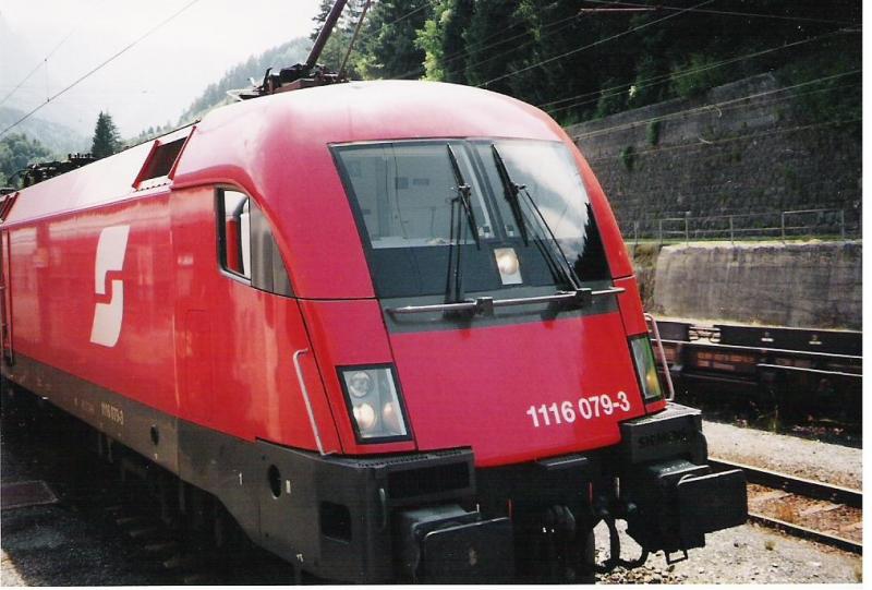 1116 079-3 wartet in Rosenbach/sterreich auf eine neue Aufgabe. Im Hintergrund fhrt die  Rollende Landstrae  nach Slowenien durch den sterreichischen Grenzbahnhof.