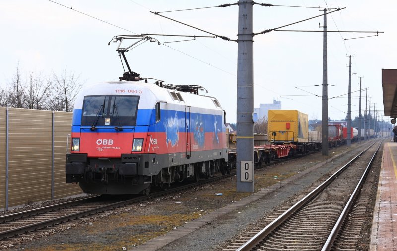 1116 084 mit einem Containerzug bei der Ausfahrt aus dem Bahnhof Marchtrenk am 21. 03. 2009.