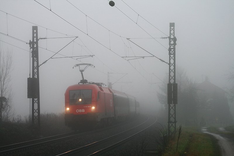 1116 128 kmpft sich am 23. Dezember 2008 mit dem EC 113 von Frankfurt (Main) nach Klagenfurt bei Wiesloch durch den dichten Morgennebel. Untersttzt wurde die Lok dabei durch die am Zugschluss schiebende 1116 110.