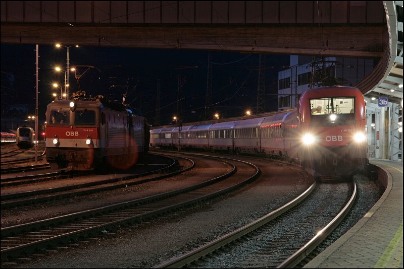 1116 183 wartet mit dem OEC auf die Weiterfahrt in Richtung Innsbruck. Auf dem Seitengleis wartet 1144 241 und eine Schwesterlok mit einem Gterzug.