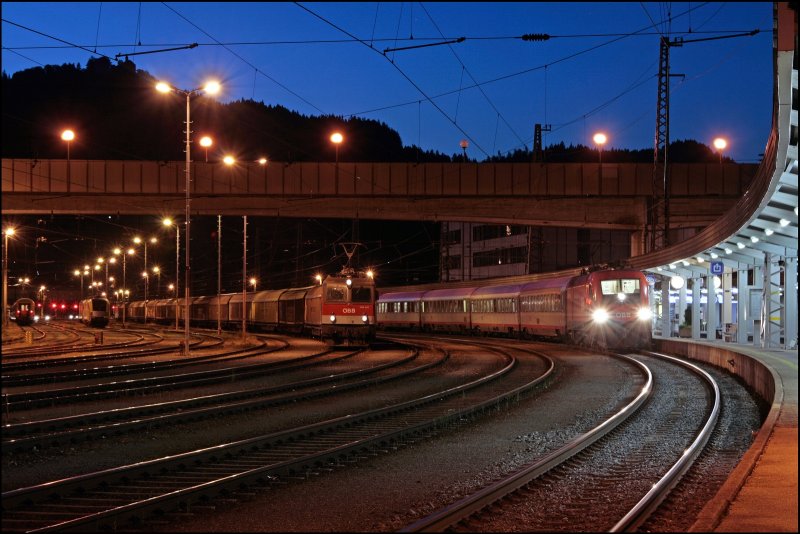 1116 183 wartet mit dem OEC 660  URLAUB AM BAUERNHOF  am Bahnsteig auf die Weiterfahrt. Auf dem Nebengleis wartet 1144 241 (9181 1144 241-7) und eine Schwesterlok mit einem Schiebewandwagenganzzug auf die Fahrt zum Brenner. 