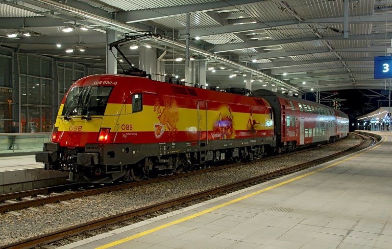 1116 232 in den Farben Spaniens schiebt einen Regionalzug. Die Aufnahme entstand im Bahnhof Wien Praterstern am 04.02.2008.