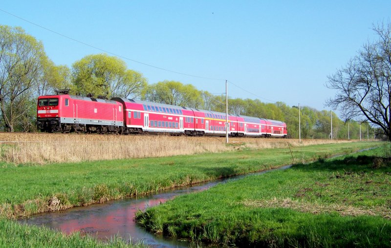 112 133-4 kommt hier mit dem RE2 aus Cottbus nach Wittenberge angebraust. Aufnahmeort liegt zwischen Raddusch und Lbbenau/Spreewald. 13.04.2009