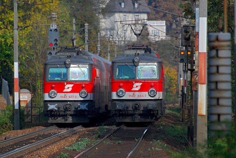 1142 677 bringt den R 2026 nach St. Poelten Hbf., 1142 665 befindet sich mit dem R 2027 auf dem Weg nach Wien Westbahnhof.
Das Foto entstand am 19.10.2008 kurz nach der Haltestelle Pressbaum.