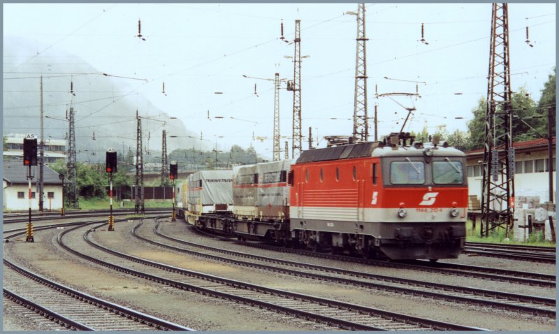 1144 213 schiebt einen schweren Kombizug von Kufstein zum Brennerpass. Aufgenommen im Bahnhof Kufstein im Sommer 2005