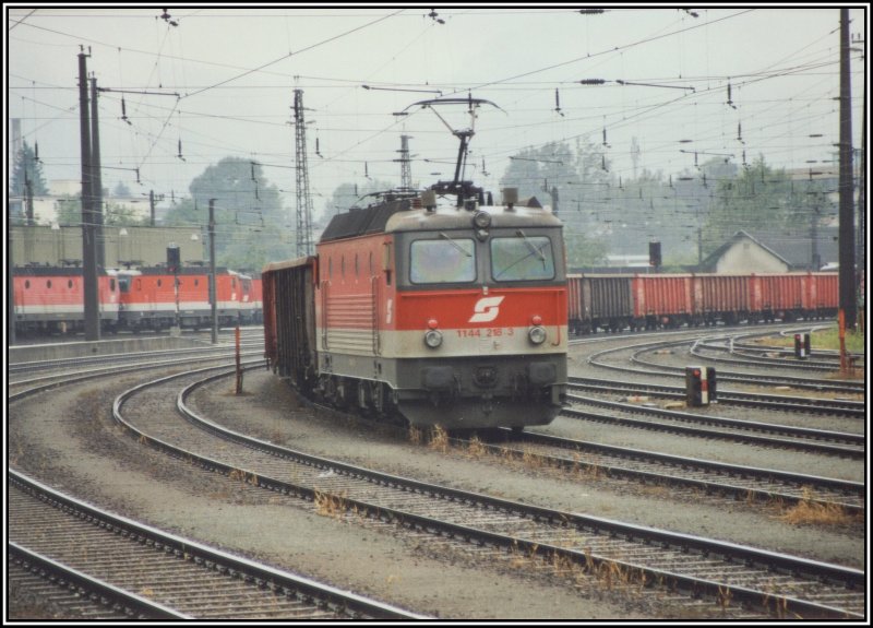 1144 218 schiebt den Gterzug, bestehend aus 14 Eanos-Waggons, zum Brenner nach. Aufgenommen im Sommer 2005 im Bahnhof Kufstein. Im Hintergrund warten weitere 1144er auf die nchsten Einstze.
