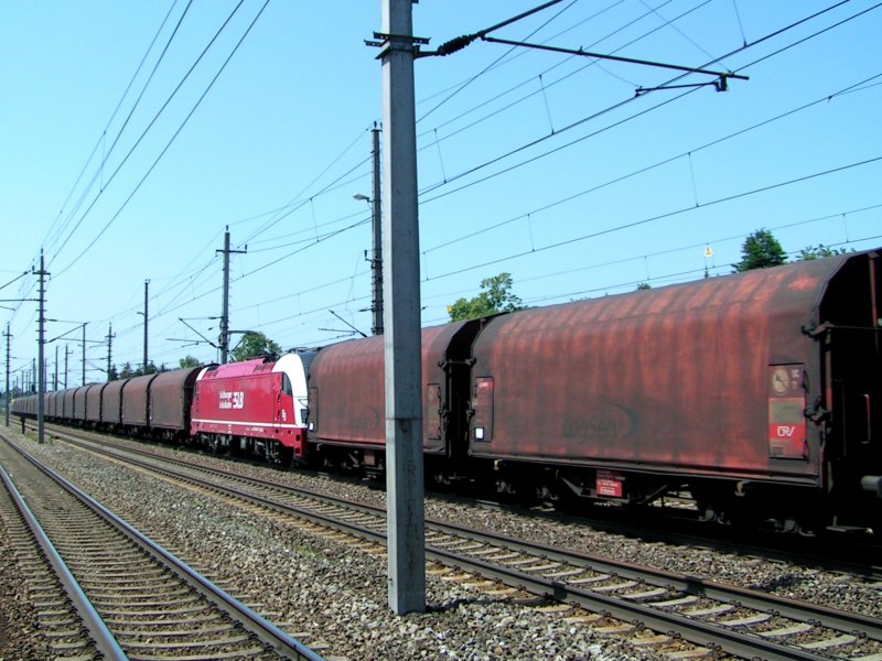 1216940 der SLB ist als Zwischenlok in einem LogservZugverband eingereiht, und passiert gerade Bhf. Marchtrenk; 090525