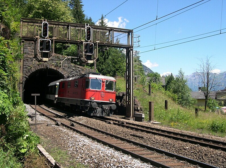 125 Jahre Gotthardbahn - Den 259m langen Rohrbach-Tunnel hat Re 4/4 II 11157 am 07.07.2007 mit ihrem EC 106 Mailand - Basel verlassen. Nun geht es ber die Reuss in den 1084m langen Wattinger Kehrtunnel, bevor der Zug unterhalb dieser Fotostelle beim Wrterhaus noch einmal zu sehen ist. Auch dieser Zug fhrte wieder Verstrkungswagen an der Spitze.